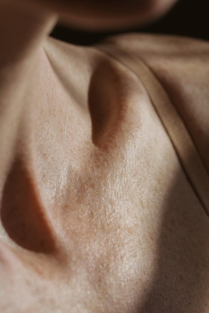 Home High-resolution close-up of a woman's collarbone and skin texture in natural light.