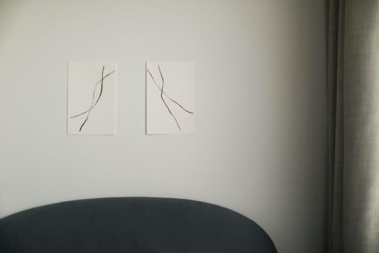 Services Abstract linear wall art in a minimalist modern living room with soft lighting.